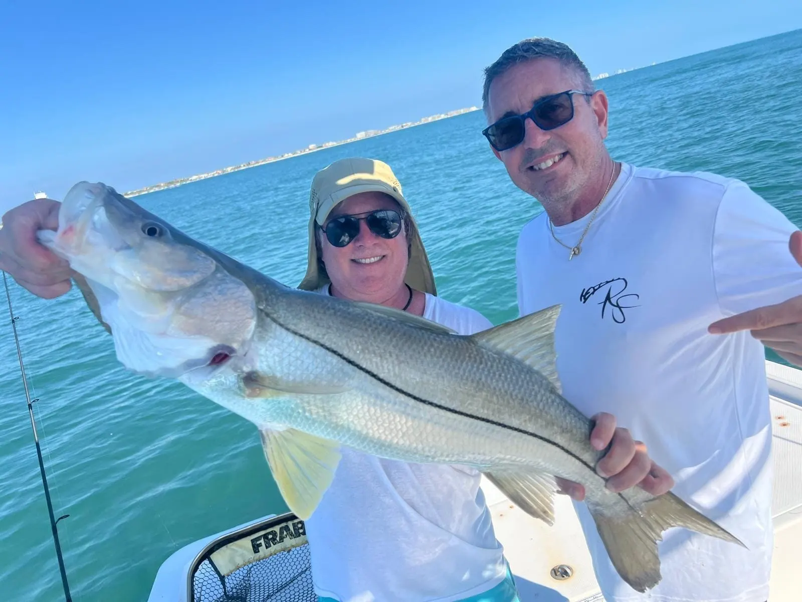 A happy angler holding a redfish, the kind of day a gift certificate buys